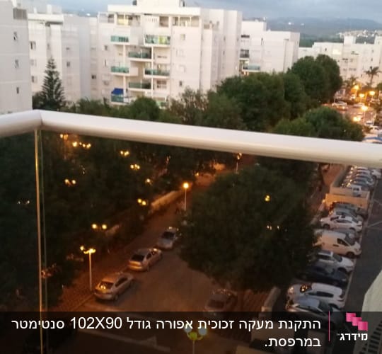 מעקה זכוכית במרפסת עם נוף עירוני